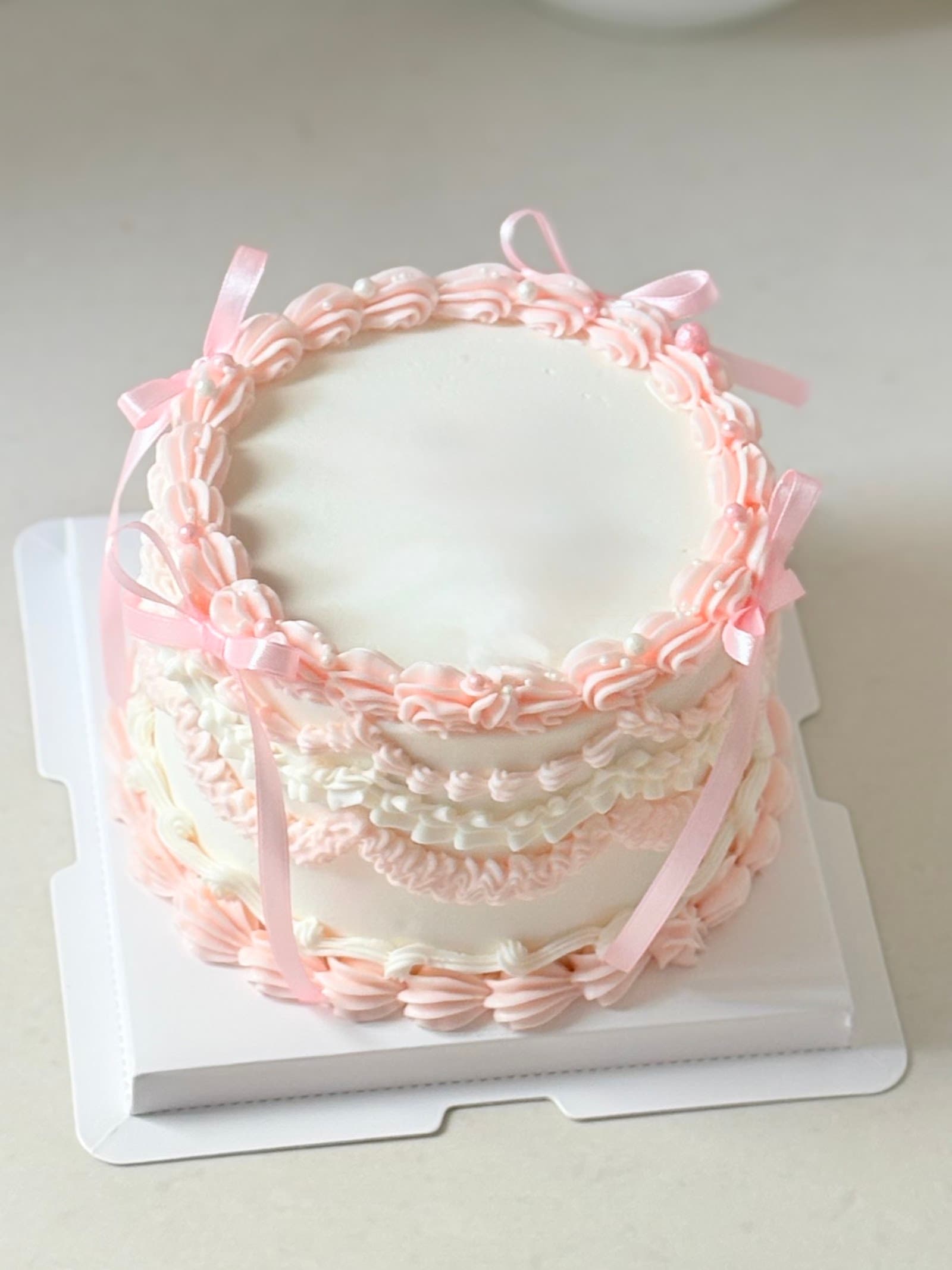 Bow vintage buttercream cake with piped rosettes and bows